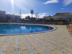 een groot zwembad met stoelen eromheen bij Sonho de férias in Portimão