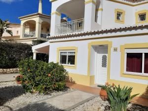 een wit en geel huis met een balkon bij Sonho de férias in Portimão