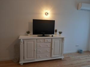 a tv sitting on top of a white dresser at Apartamento da Praia in Odeceixe