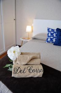 un letto con due asciugamani e fiori sopra di Le Case di Sonia DEL CORSO CIV 25 Fucecchio a Fucecchio