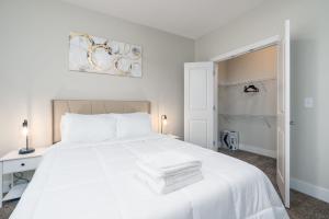 a white bedroom with a white bed and a desk at Stylish 1BR in at the Crossing in Indianapolis