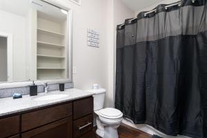 a bathroom with a black shower curtain and a toilet at Stylish 1BR in at the Crossing in Indianapolis