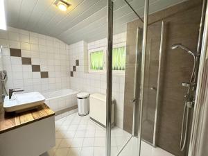 uma casa de banho com um chuveiro e um lavatório. em Le Bain du Corbeau - Schwarzwald-Villa Alpirsbach em Alpirsbach
