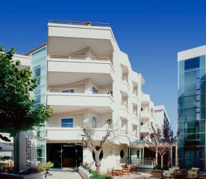 a white building with trees in front of it at Hotel Albatros in Misano Adriatico