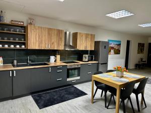 a kitchen with wooden cabinets and a table with chairs at Apartmán Pantáreň in Čadca