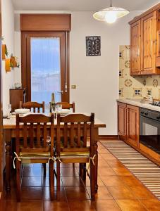 uma cozinha com uma mesa e cadeiras numa cozinha em San Dona Homely House em San Donà di Piave