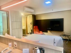 una habitación con espejo y una persona en una habitación en Suites Inside Hotel Patio Paulista, en São Paulo