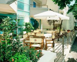 um restaurante ao ar livre com mesas e guarda-sóis em Hotel Albatros em Misano Adriatico