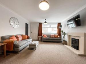 a living room with two couches and a fireplace at Well Situated, Cosy 2 Bed House in West Kirby