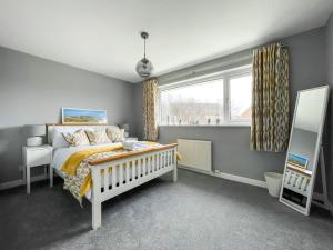 a bedroom with a bed and a window at Well Situated, Cosy 2 Bed House in West Kirby