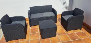 three black chairs and a table on a tile floor at Can Carles - Delta del Ebro in El Poblenou del Delta