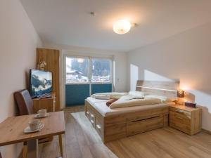 una camera con letto, tavolo e finestra di Blaiken Appartements in Scheffau am Wilden Kaiser a Scheffau am Wilden Kaiser