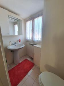Un baño blanco con lavabo e inodoro. en La casa sul tetto, en Stresa 13 fotos más