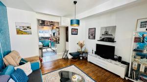 ein Wohnzimmer mit einem Sofa und einem TV in der Unterkunft Appartement Bleu du Palais - Relaxation Centrale in Le Palais