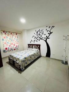 sypialnia z łóżkiem z drzewem na ścianie w obiekcie Apartamento lujoso frente al mar 2 w mieście Crucita