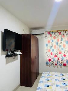 sypialnia z telewizorem z płaskim ekranem na ścianie w obiekcie Apartamento lujoso frente al mar 2 w mieście Crucita