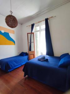 1 dormitorio con 2 camas y ventana en La Galería B&B, en Valparaíso