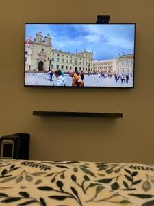 a flat screen tv hanging on a wall above a bed at Cal Bed & Breakfast in Bogotá