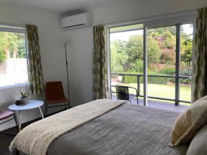 a bedroom with a bed and a large window at Kauri Point Village in Tahawai