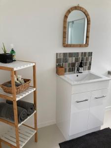 een badkamer met een witte wastafel en een spiegel bij Kauri Point Village in Tahawai