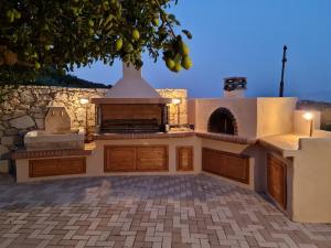 an outdoor kitchen with a pizza oven in a yard at ONOMY Country House Vathypetro in Archanes