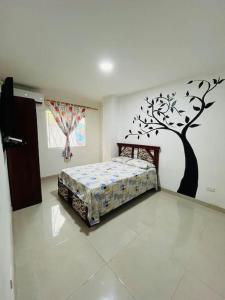 a bedroom with a bed with a tree on the wall at Apartamento lujoso frente al mar in Crucita