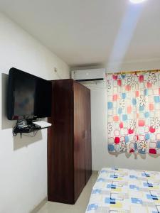 a bedroom with a flat screen tv on a wall at Apartamento lujoso frente al mar in Crucita