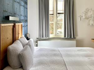 sypialnia z łóżkiem i oknem w obiekcie Hotel Au Nom De Dieu w mieście Dilsen-Stokkem