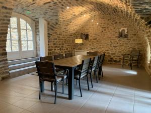 comedor con mesa de madera y sillas en Gîte l'oustal de la fontaine Grand Causses et Gorges du Tarn, en Mostuéjouls