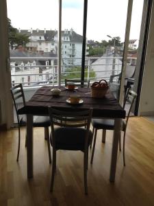 a table and chairs with a view of a balcony at Appartement Le Rev in La Baule