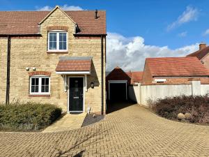 a brick house with a driveway and a garage at Homely 3 bedroomed House in Bicester in Bicester