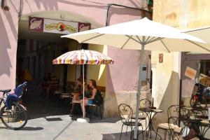 twee mensen zitten aan een tafel onder een paraplu bij Jazz Apartments in Piran