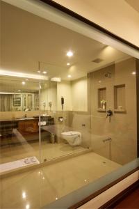 a bathroom with a glass shower and a toilet at Hotel Express Residency Vadodara in Vadodara