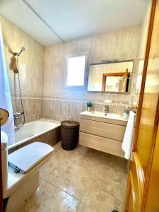a bathroom with a tub and a toilet and a sink at Apartamento MariaLuisa in Oliva