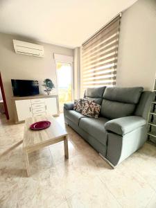 een woonkamer met een bank en een salontafel bij Apartamento MariaLuisa in Oliva