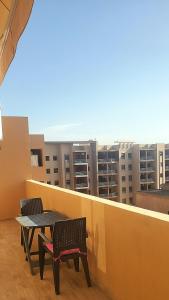 een balkon met een tafel en stoelen in een gebouw bij Appartement tout neuf en plein centre de Marrakech in Marrakesh