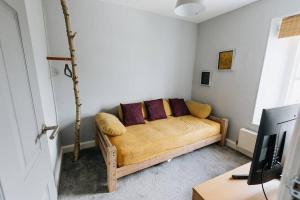 a living room with a couch with purple pillows at HOLLINS NOOK - Countryside House - Gateway to Lakes National Park in Burneside