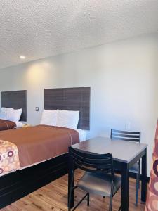 Habitación con cama, mesa y cama en Coachway Inn, en Luling