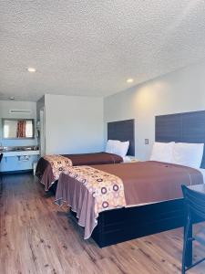 a hotel room with two beds and a table and chairs at Coachway Inn in Luling