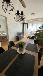 a living room with a dining table and a living room with a bed at Apartment Unamare in Belgrade