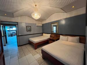 a bedroom with two beds and a chandelier at Hotel Wilson Tulipan Los Chiles in Los Chiles
