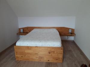 um quarto com uma cama de madeira num quarto em Faimaison em Petit Vaux