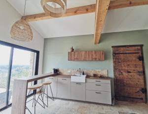 una cucina con armadietti bianchi e porta in legno di LE CABANON 2.42 a Le Thor