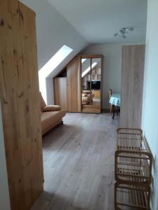 uma sala de estar com um sofá e um piso de madeira em Faimaison em Petit Vaux
