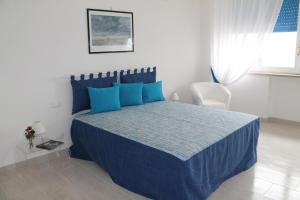 a bedroom with a bed with blue pillows at Atlantis in Trapani