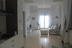 a white living room with a couch and a window at Atlantis in Trapani