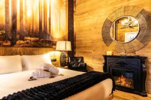 a bedroom with a bed with a fireplace and a mirror at BAITA MAORE luxury rooms & Spa in Làconi