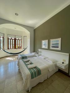 1 dormitorio con 2 camas y hamaca. en Pousada Casa Imperatriz - Rua Teresa, en Petrópolis