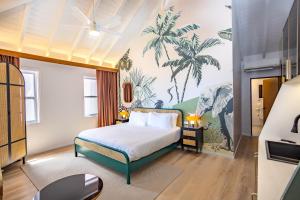 a bedroom with a bed and a palm tree mural at The Pink Palm Hotel - Adults Only in Charlotte Amalie