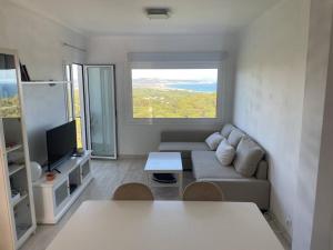 een woonkamer met een bank en een televisie bij NUEVO. Reformado con vistas panorámicas y piscina in Pals